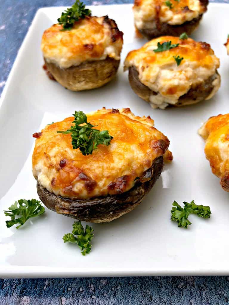 cooked stuffed mushroom with cheese on a white plate
