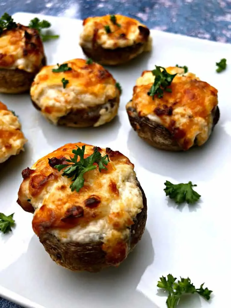 cooked stuffed mushroom with cheese on a white plate