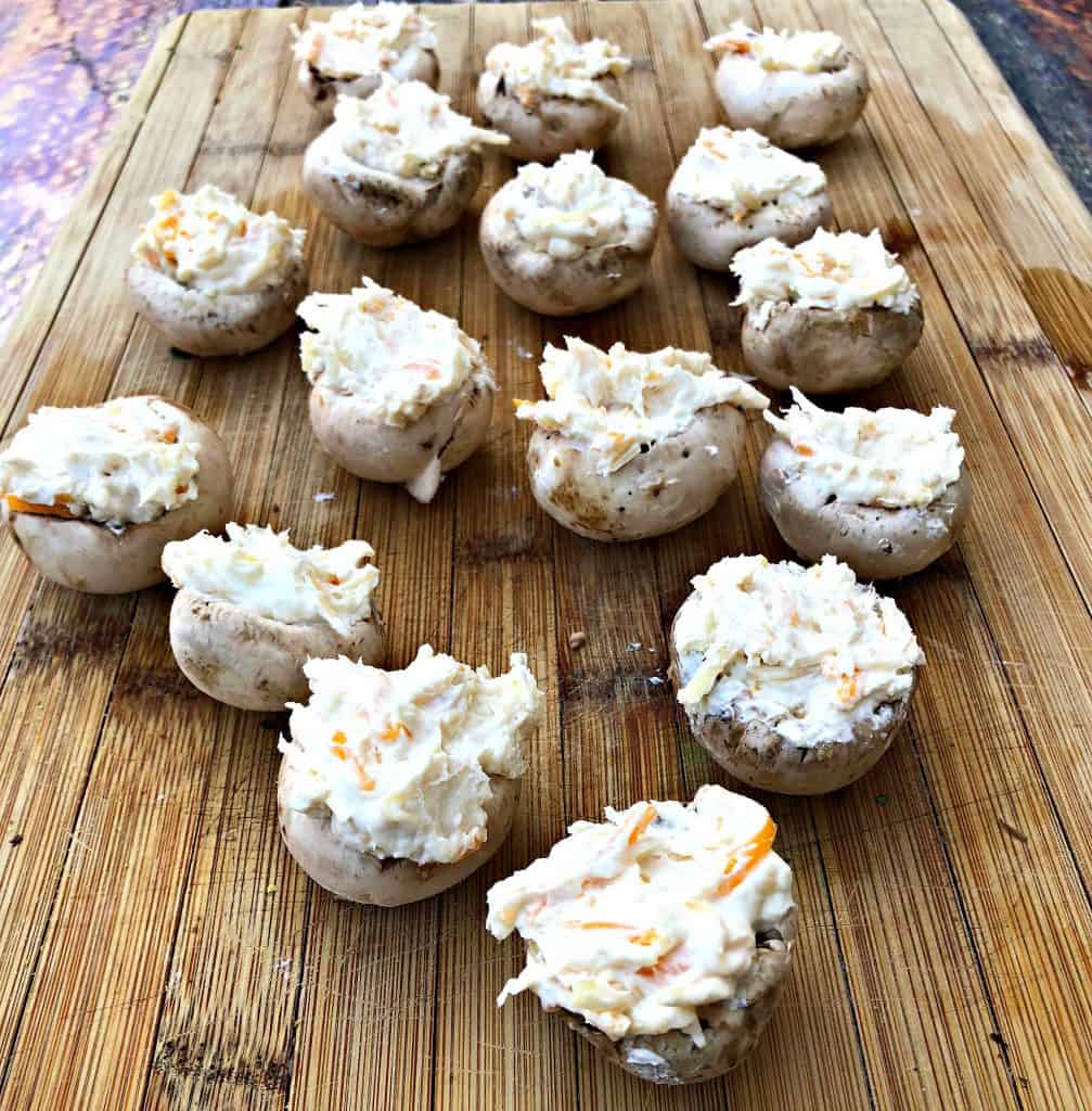 raw mushrooms stuffed with shredded cheese and cream cheese