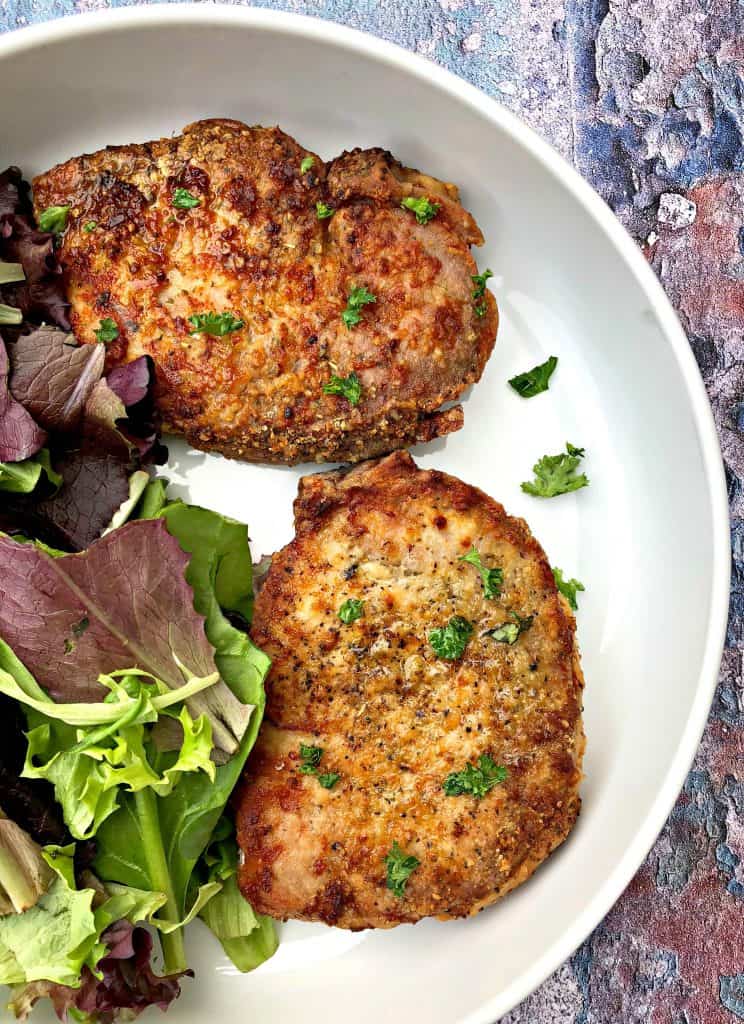 air fryer pork chops in a white bowl with salad