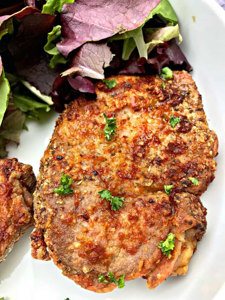 air fryer pork chops in a white bowl with salad