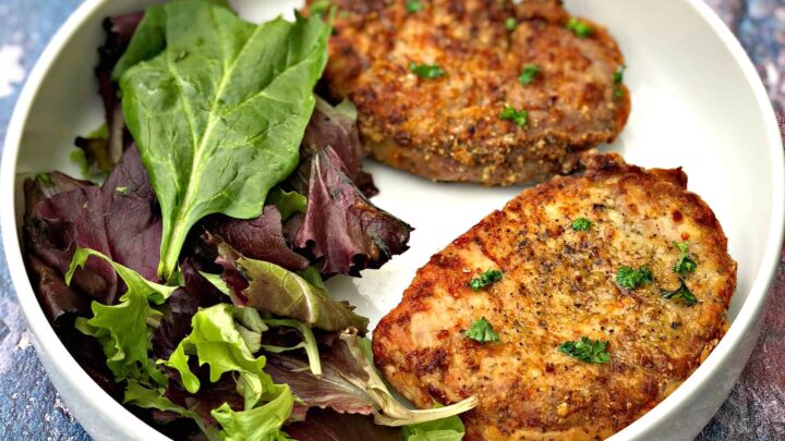 air fryer pork chops in a white bowl with salad