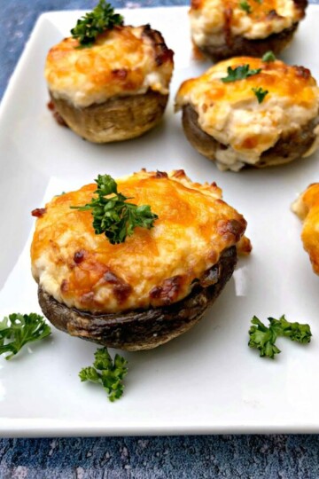 cooked stuffed mushroom with cheese on a white plate