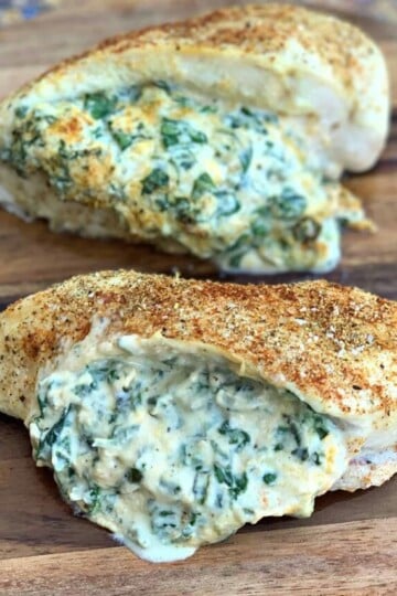 keto low carb stuffed chicken breasts on a wooden cutting board