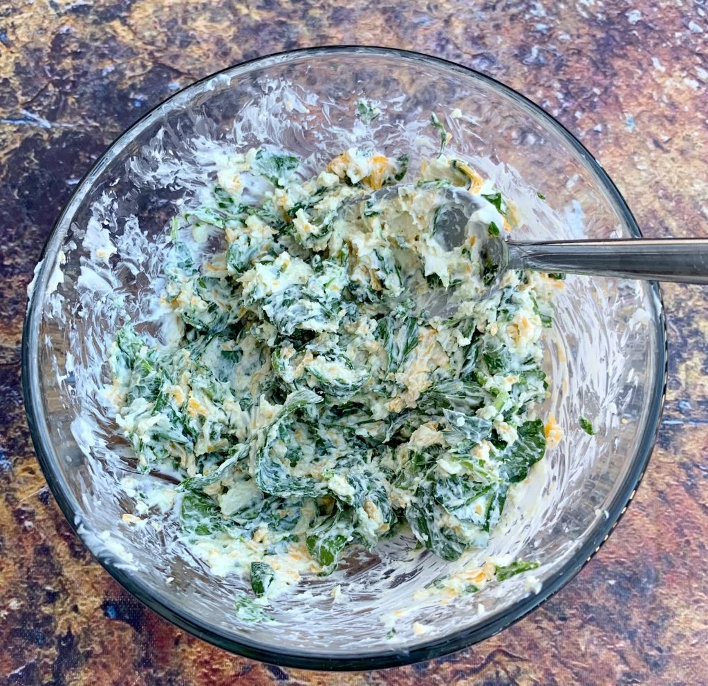 cream cheese, spinach, and cheddar mixed in a bowl