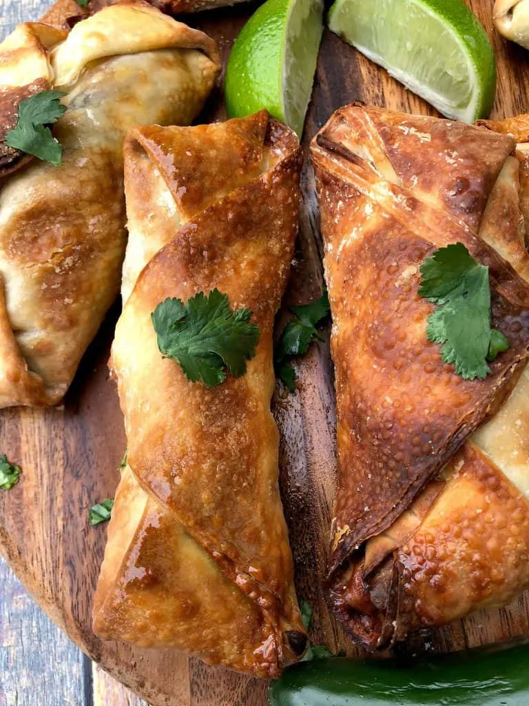 air fryer southwestern egg rolls spread out on a brown cutting board