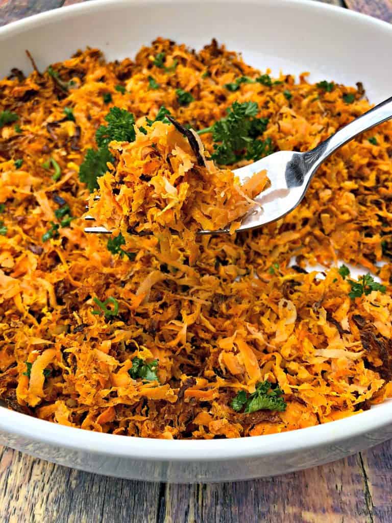 sweet potato hash browns scooped with a fork in a white bowl