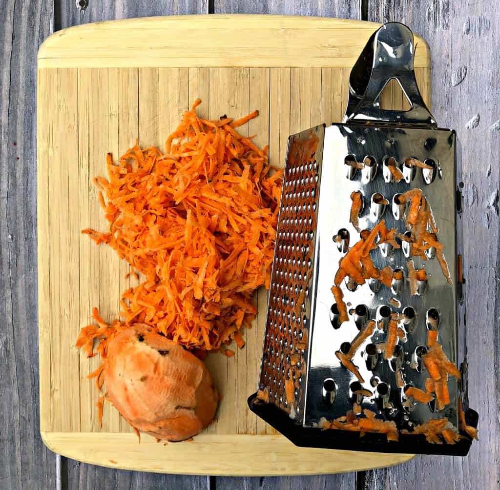 raw sweet potato shredded next to a cheese grater