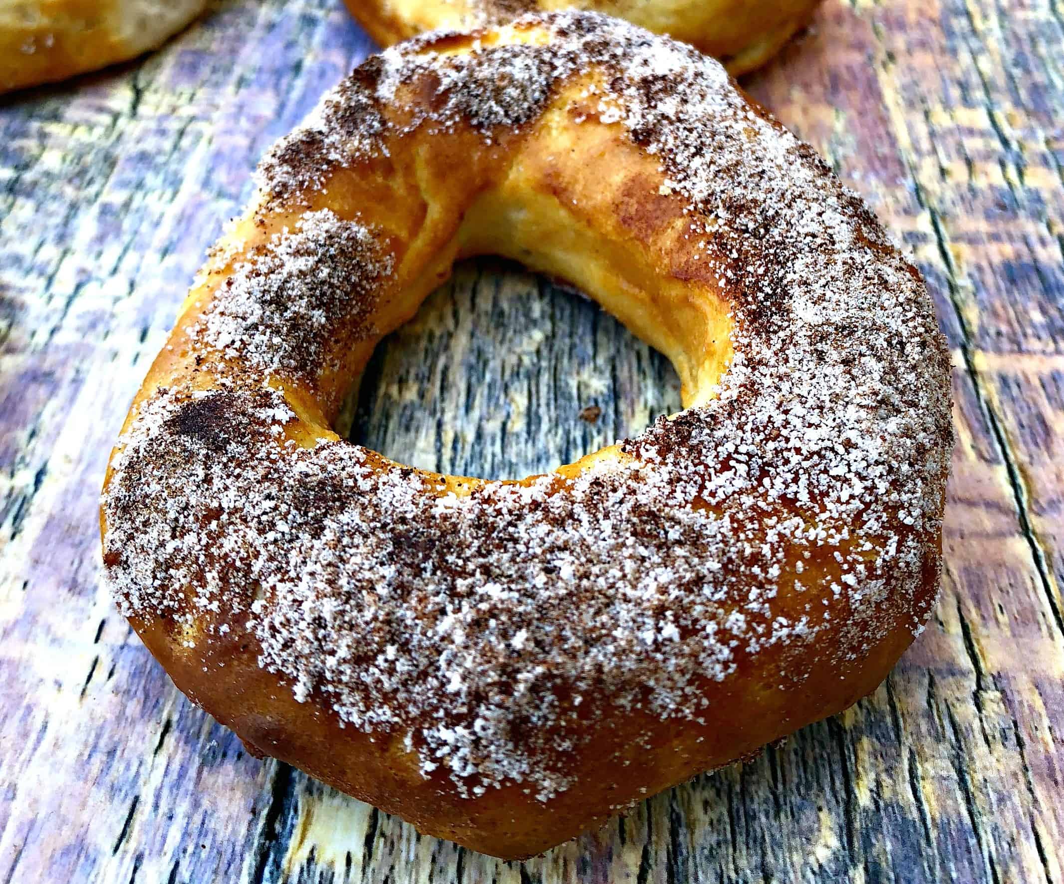 Air Fryer Cinnamon Sugar Donuts on a multi colored surfaced