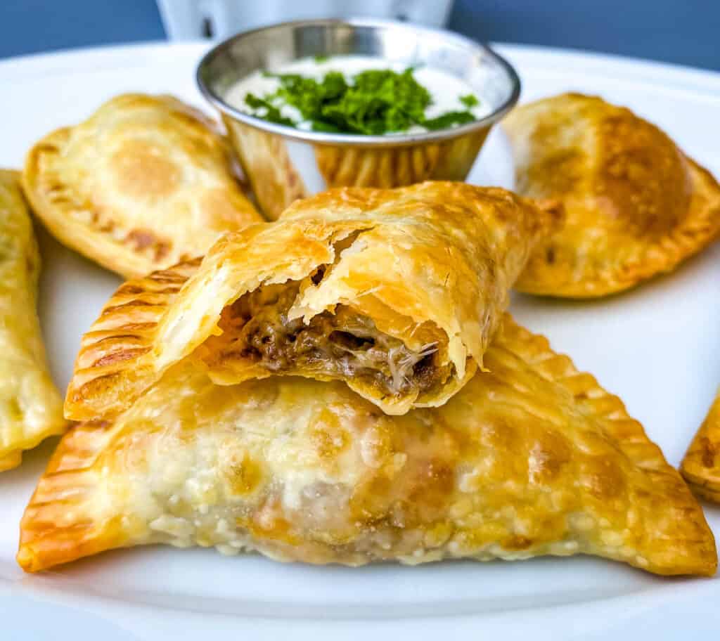 beef and cheese empanada on a white plate