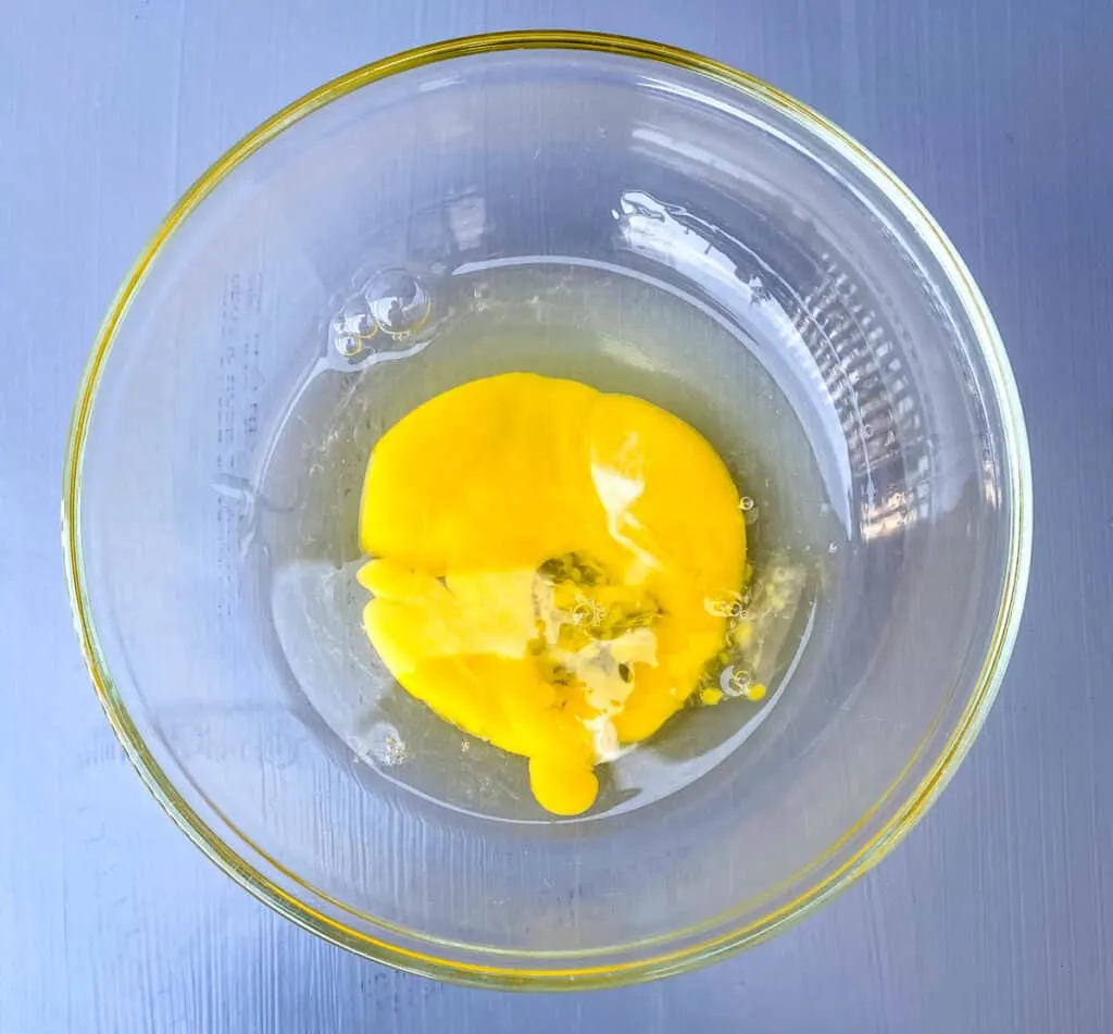 a beaten egg in a glass bowl