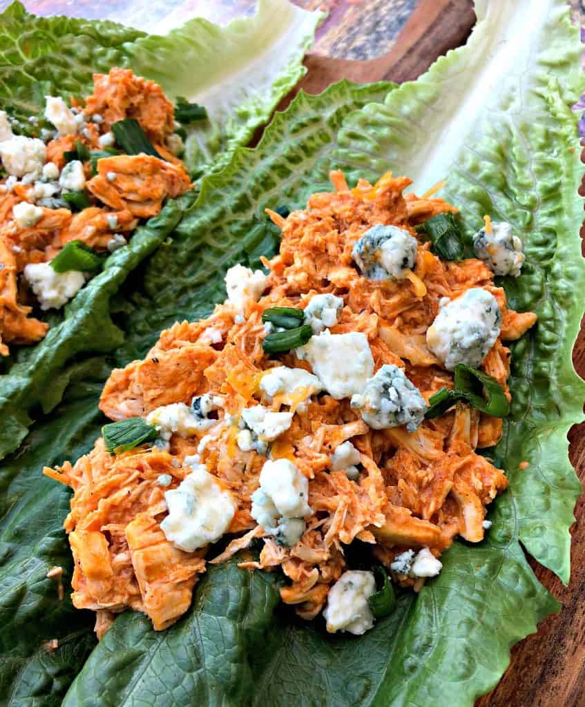 buffalo chicken wraps on romaine lettuce on a cutting board with blue cheese