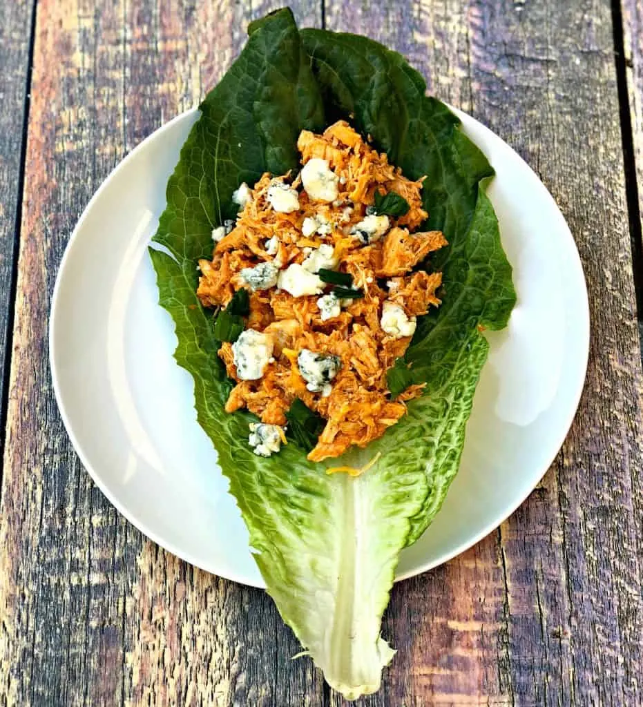 buffalo chicken wraps on romaine lettuce on a cutting board with blue cheese