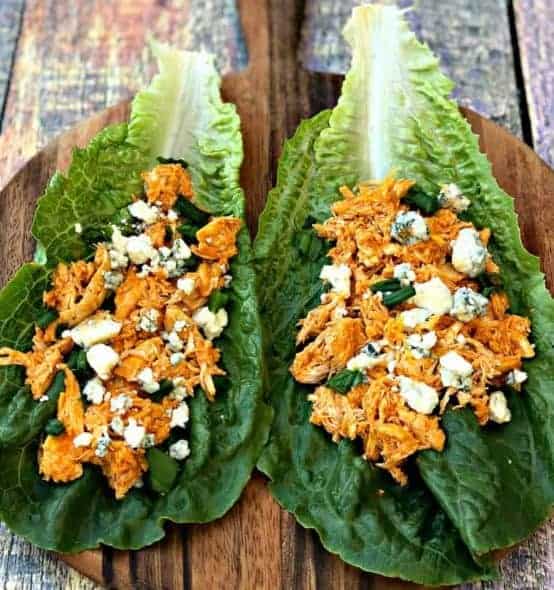 buffalo chicken wraps buffalo chicken wraps on romaine lettuce on a cutting board with blue cheese