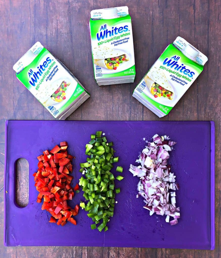 chopped red and green peppers and chopped onions on a purple cutting board
