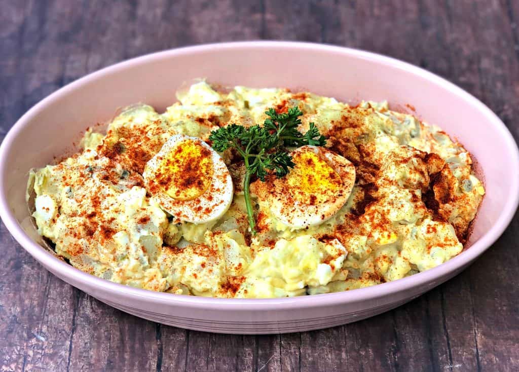 instant pot potato salad with boiled eggs in a pink bowl