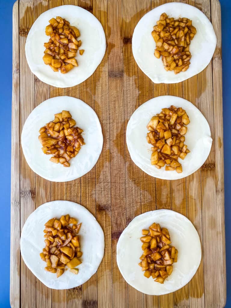 empanadas on a cutting board with apple filling