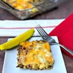 keto cheeseburger casserole with pickle on a white plate