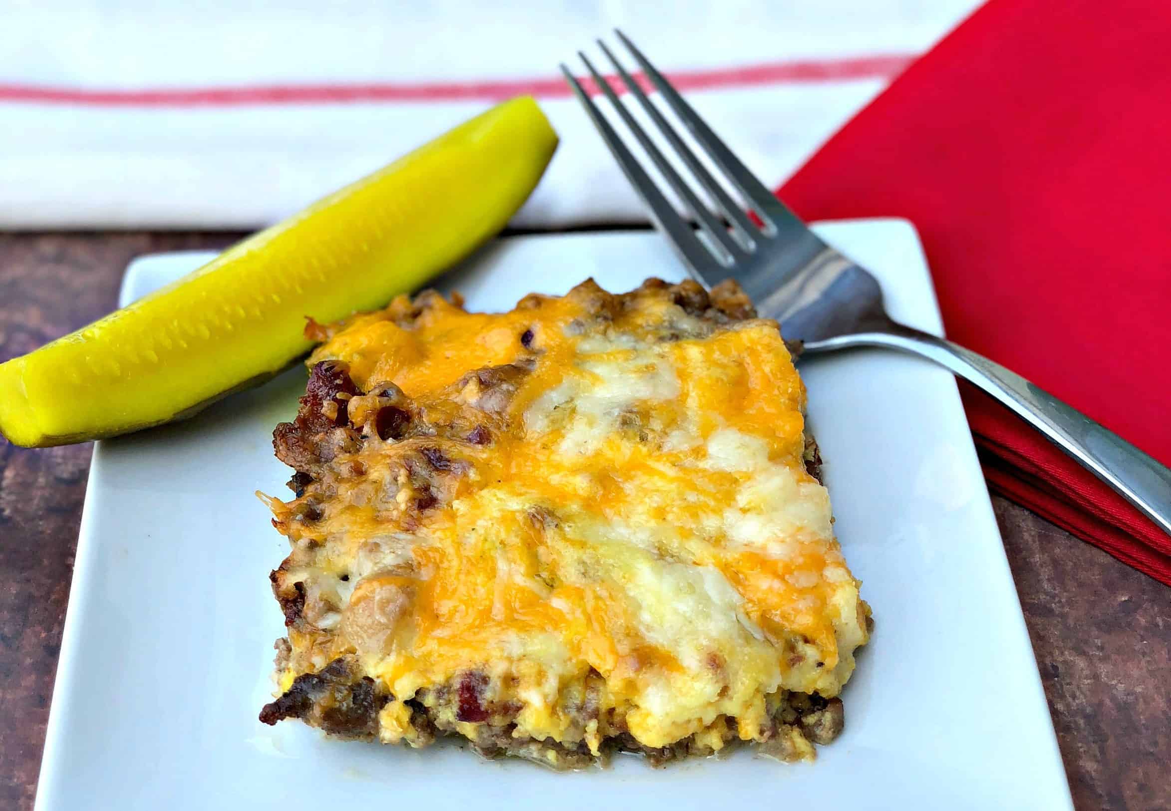 keto cheeseburger casserole with pickle on a white plate