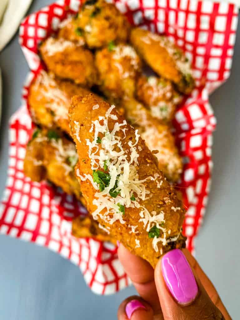 person holding a garlic parmesan chicken wing