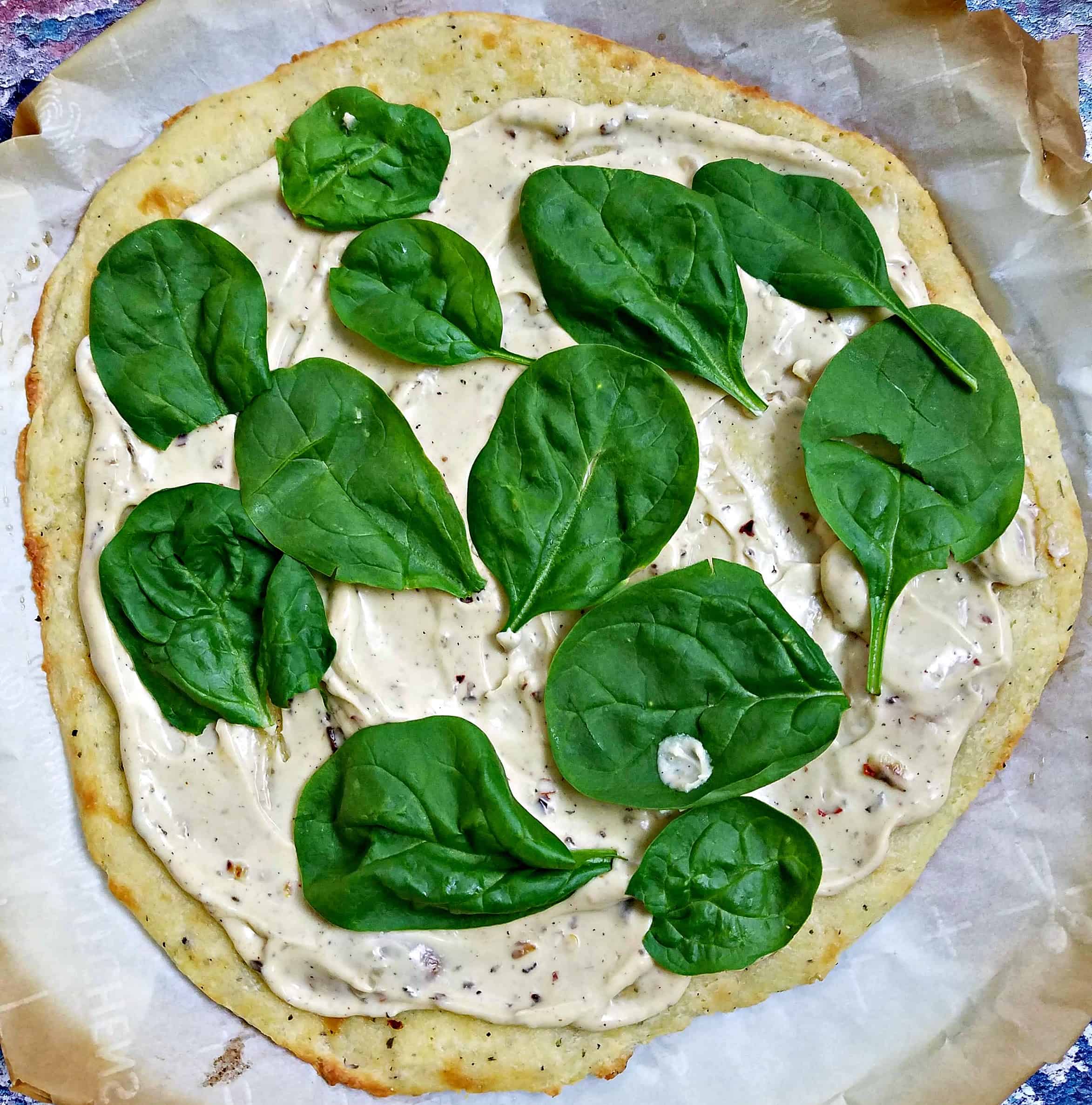 uncooked pizza with spinach