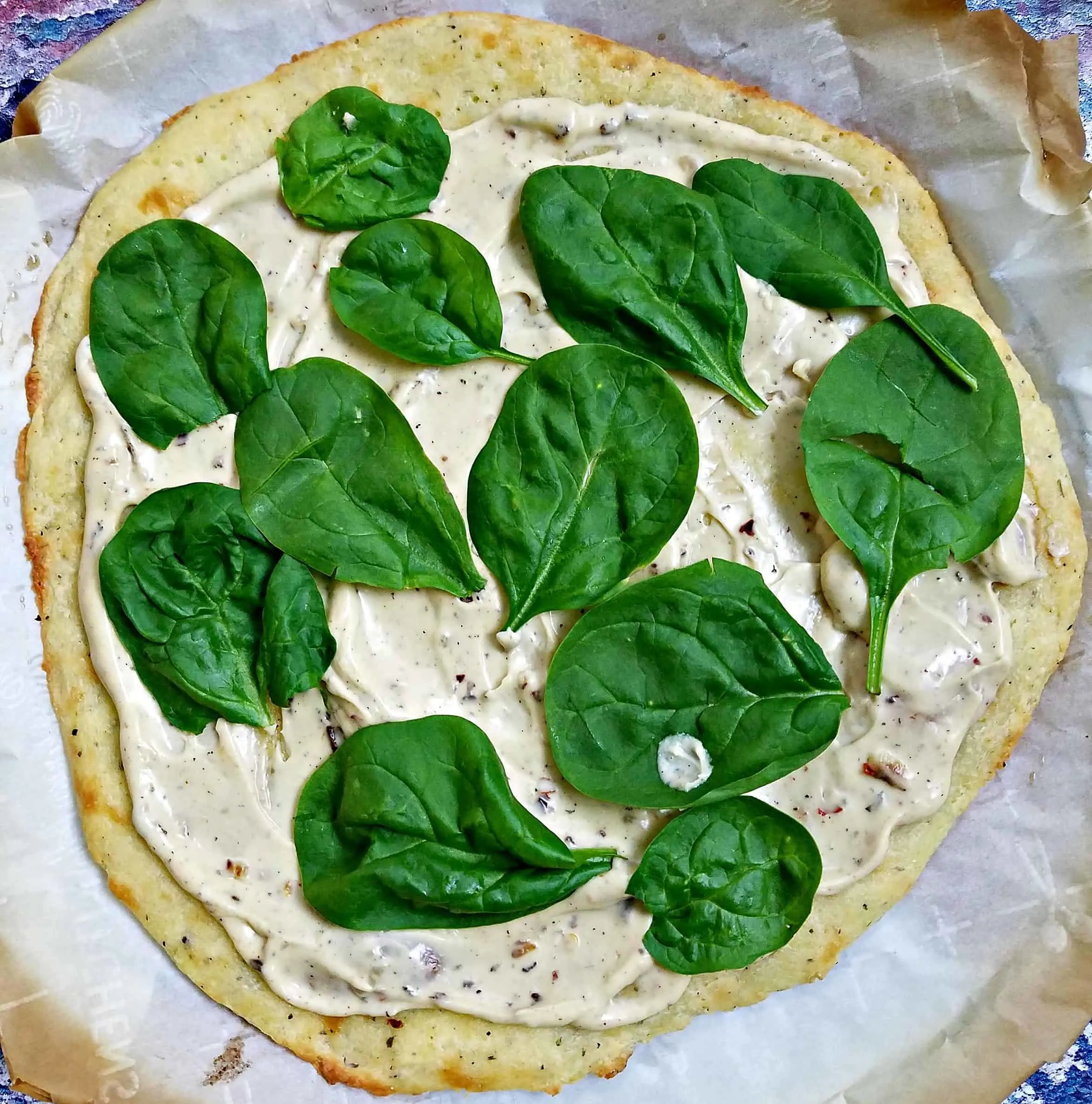 uncooked pizza with spinach