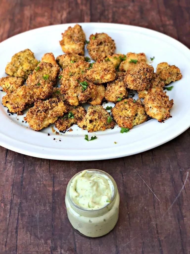 2 keto bacon chicken nuggets on a white plate with avocado ranch