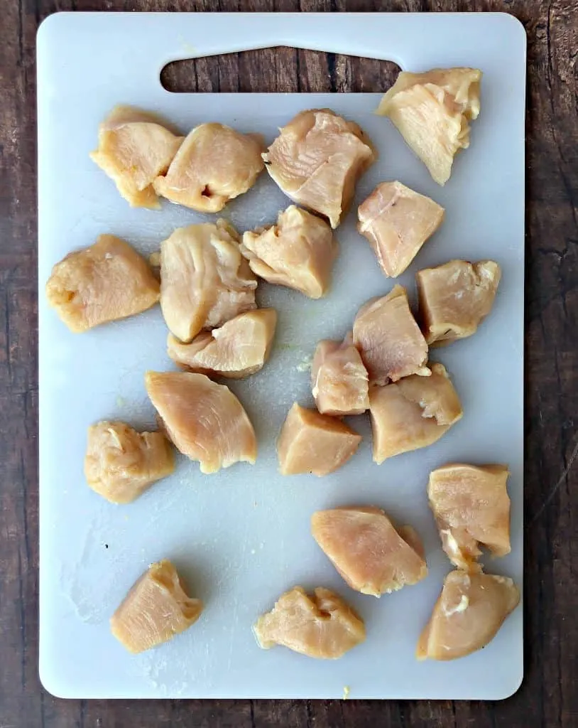 raw chicken cut in pieces on a cutting board