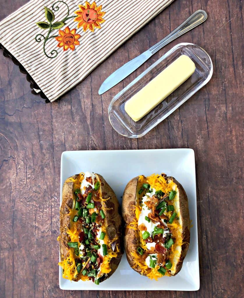 air fryer loaded baked potato on a plate with butter