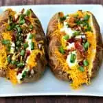 air fryer loaded baked potato on a white plate