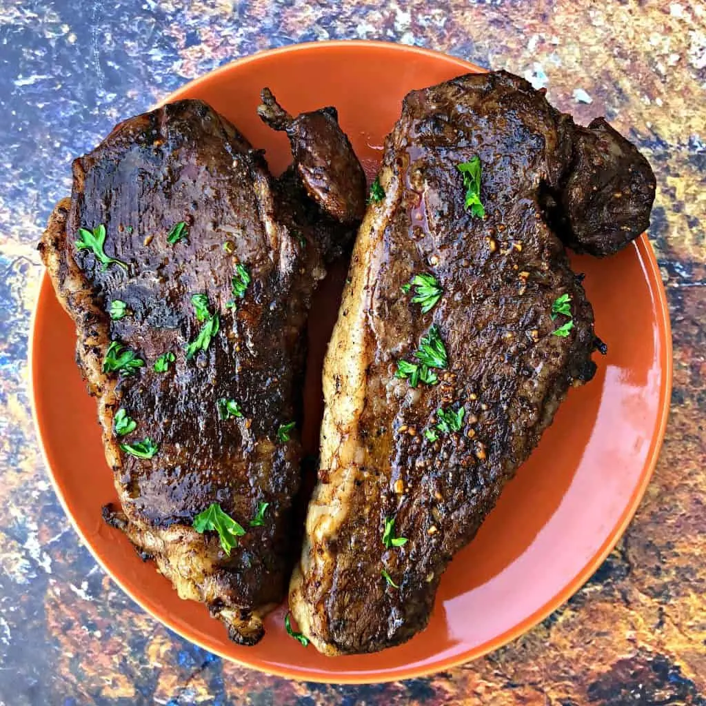 air fryer steaks on an orange plate