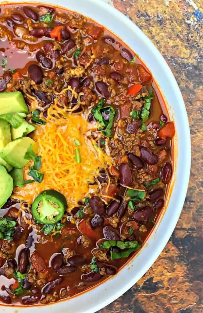 Instant Pot beef chili with shredded cheese in a white bowl
