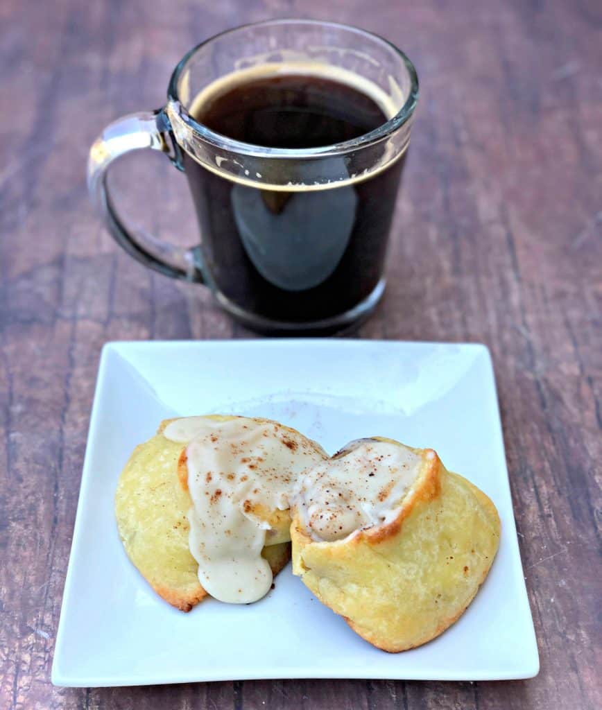 keto fathead cinnamon rolls on a white plate with coffee