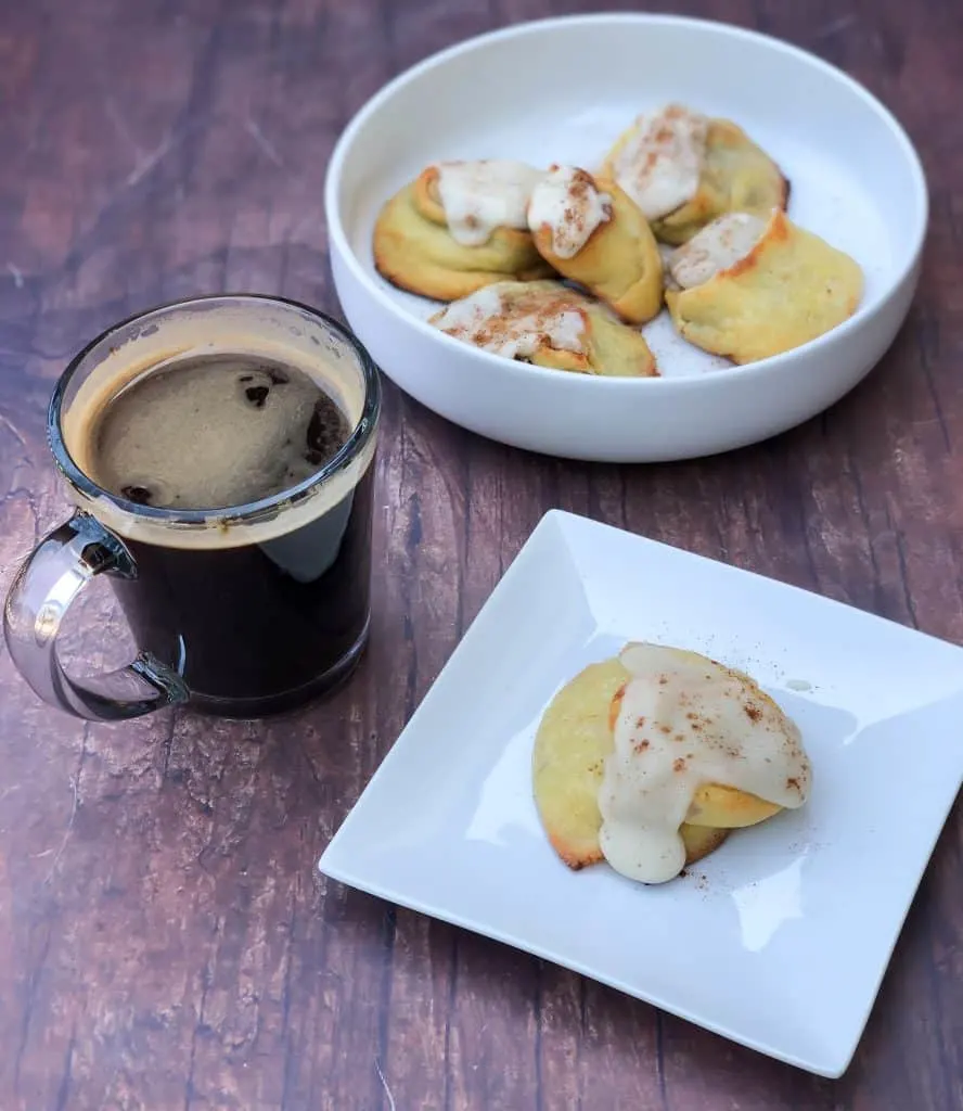 keto fathead cinnamon rolls on a white plate with coffee