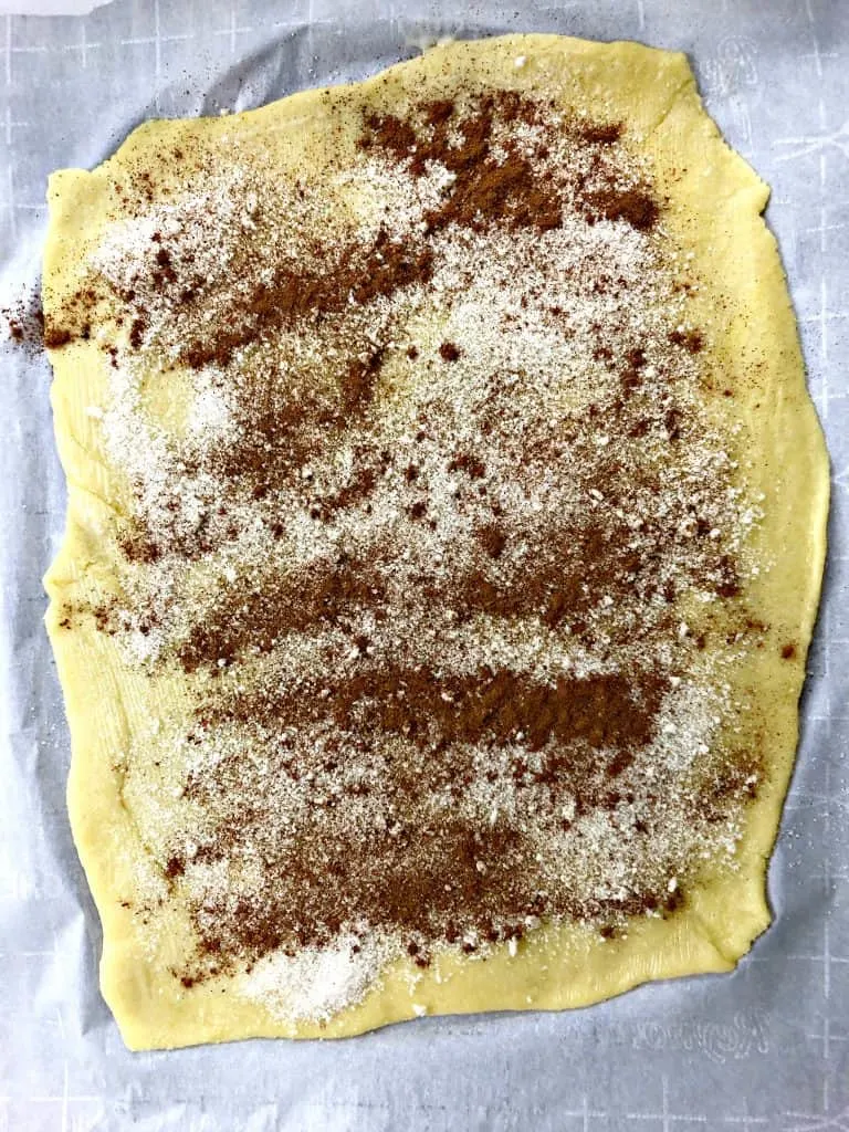 keto fathead cinnamon rolls on a white plate dough with cinnamon and sugar
