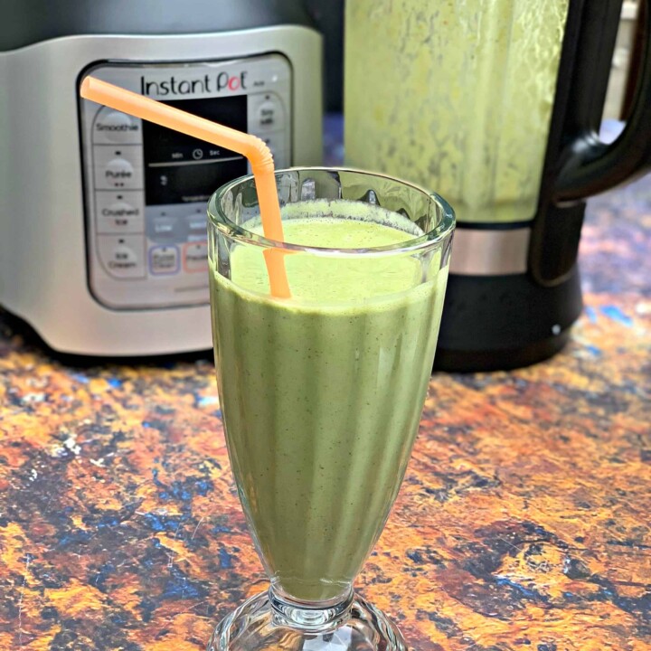 instant pot blender green smoothie in a glass with a straw