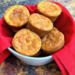 keto low carb cheesy biscuits in a white bowl lined with a red cloth napkin