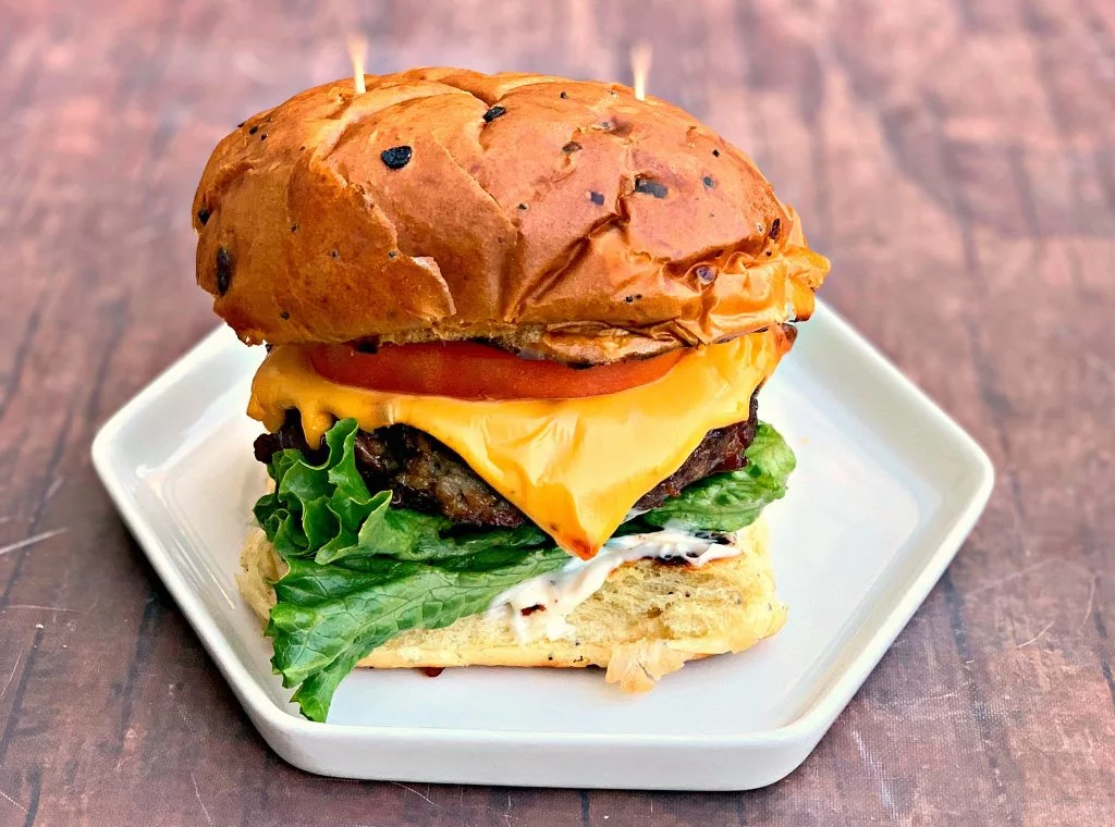 juicy air fryer cheeseburgers on a bun and white plate