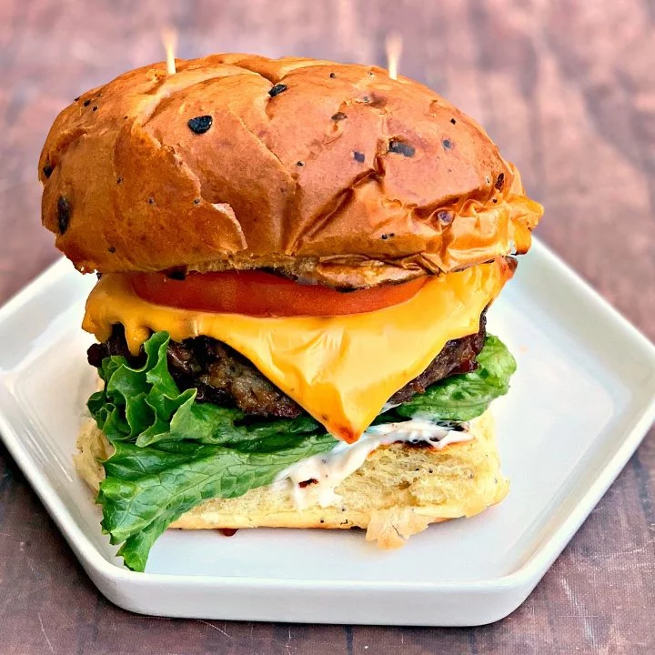 juicy air fryer cheeseburgers on a bun and white plate