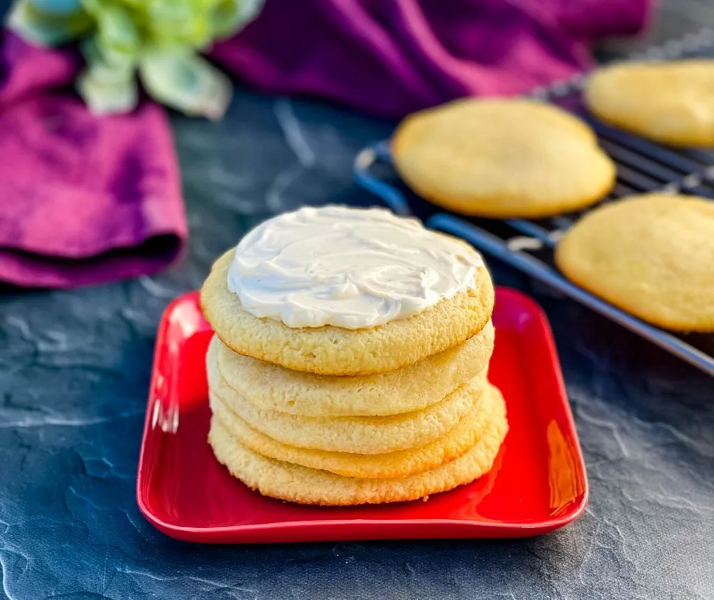 keto low carb sugar cookies on a red plate with cream cheese frosting