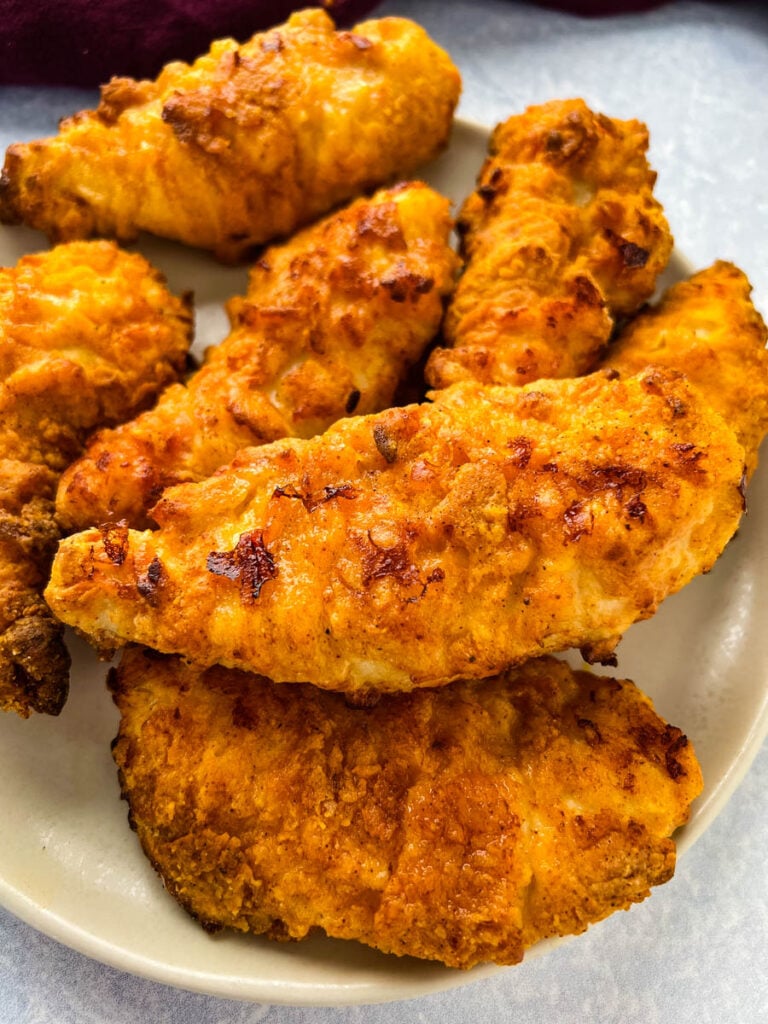 air fryer fried chicken tenders on a white plate with ranch