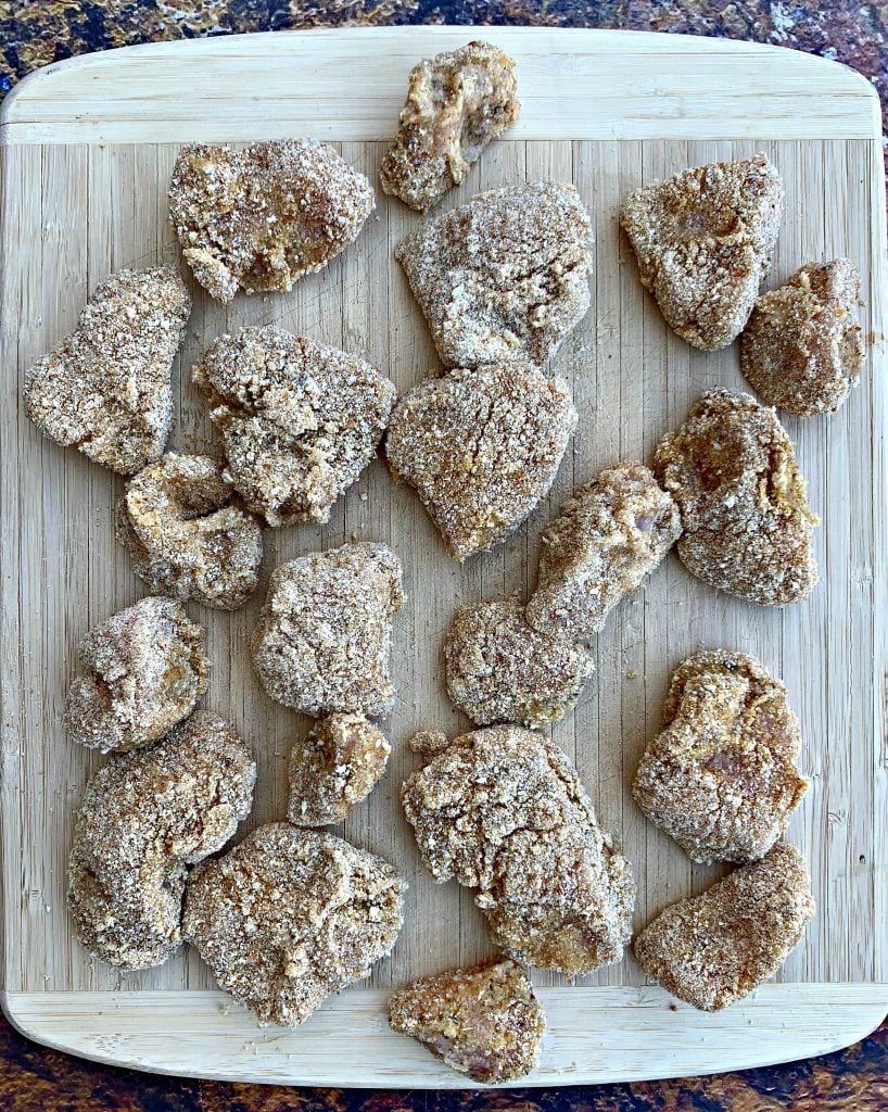 raw chicken nuggets with breading on a cutting board