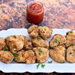 air fryer chicken nuggets on a white plate with ketchup