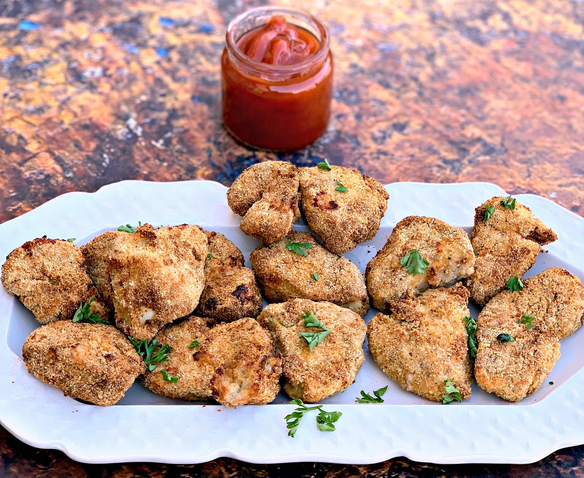 air fryer chicken nuggets on a white plate with ketchup