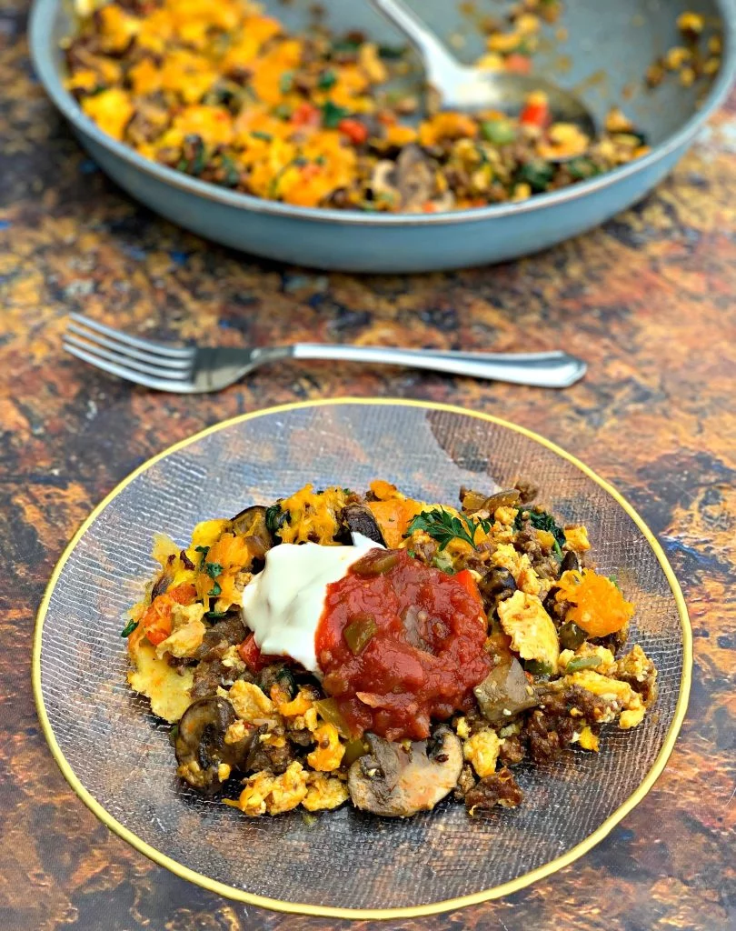 keto low carb sausage breakfast scramble on a plate with salsa and sour cream
