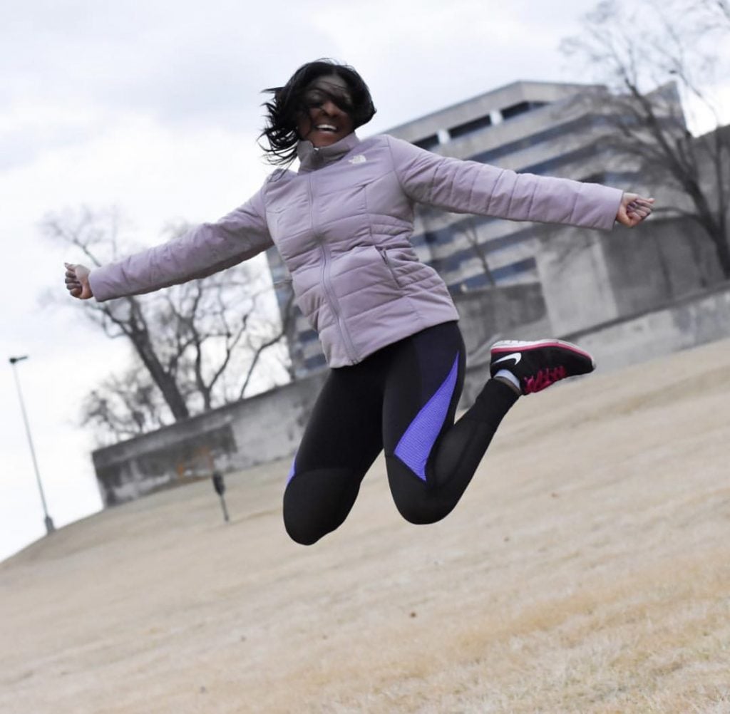 person jumping in the air in a coat