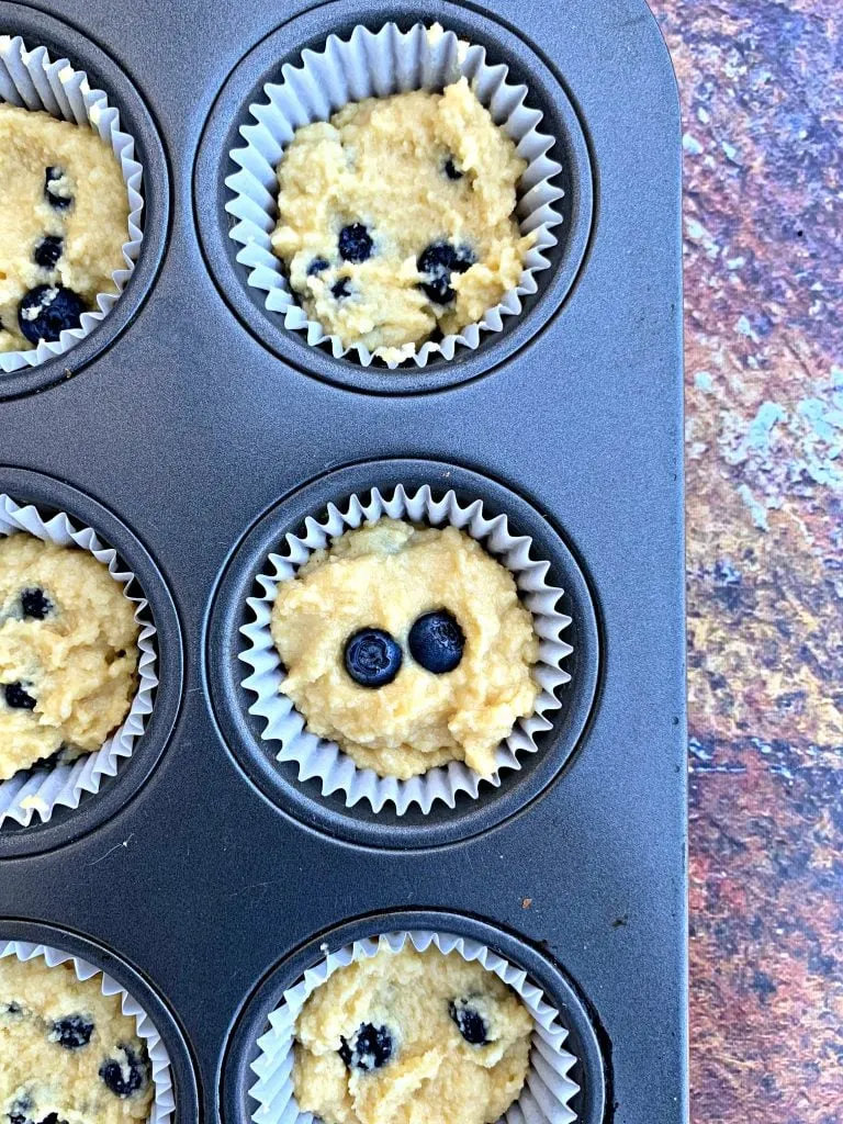 uncooked keto blueberry muffins in a muffin tin