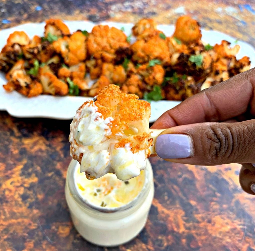 person holding keto buffalo cauliflower wings with ranch dip