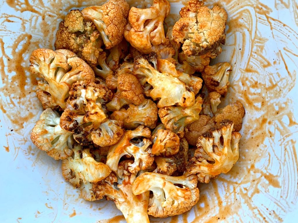 chopped cauliflower in bowl with buffalo sauce