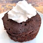 keto chocolate mug cake with whipped cream on a white plate